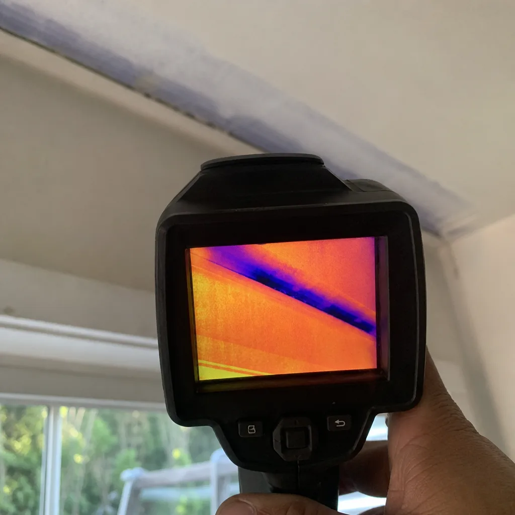 Technician performing a professional thermal imaging home energy audit in Cerritos, CA